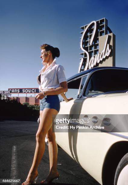 Model poses next to a 1954 Buick Roadmaster outside the Sands Hotel in 1955 in Las Vegas, Nevada.