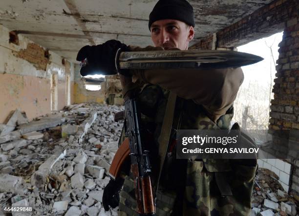 Fighter of Ukrainian volunteers battalion of Azov holds a dagger with a message reading "Glory to Ukraine !" as he rests after a military exercise...