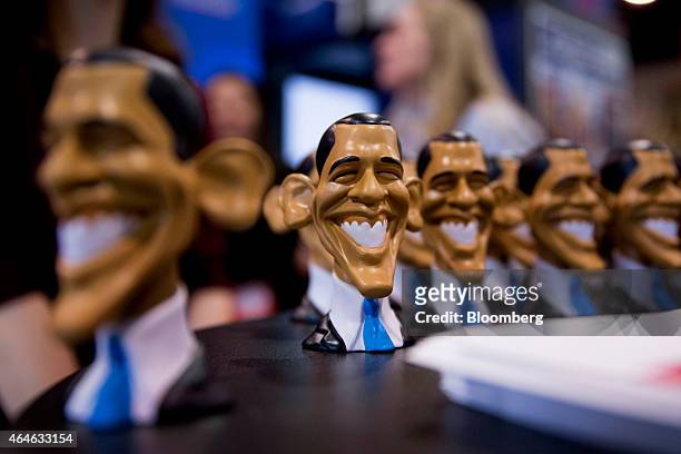 Caricatures of U.S. President Barack Obama sit on display at the Weekly Standard booth on the exhibit floor during the Conservative Political Action...