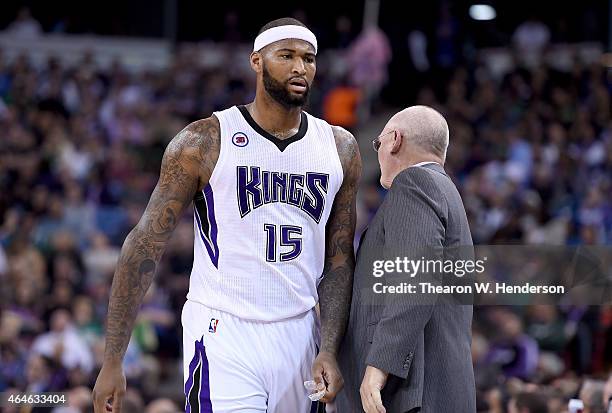 DeMarcus Cousins of the Sacramento Kings walks back to the bench past head coach George Karl after Cousins was called for a technical foul against...