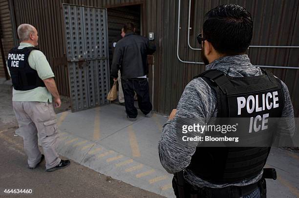 Immigration and Customs Enforcement agents look on as an undocumented man is received by a Mexican immigration agent at a removal gate of the...