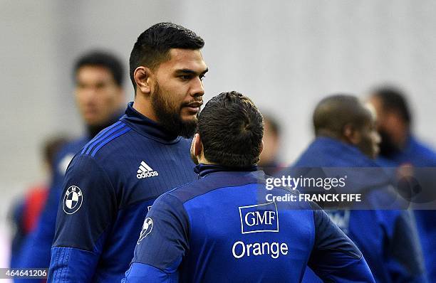 France's lock Romain Taofifenua speaks with a teammate during a training session, on February 27, 2015 at the Stade de France in Saint-Denis, north...