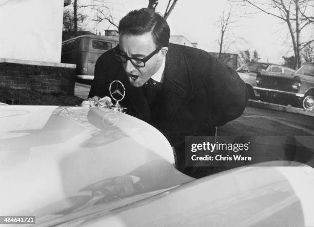 English comic actor Peter Sellers polishes his new Mercedes-Benz 300 SE Cabriolet , 7th November 1962. Sellers bought the car for eight thousand...