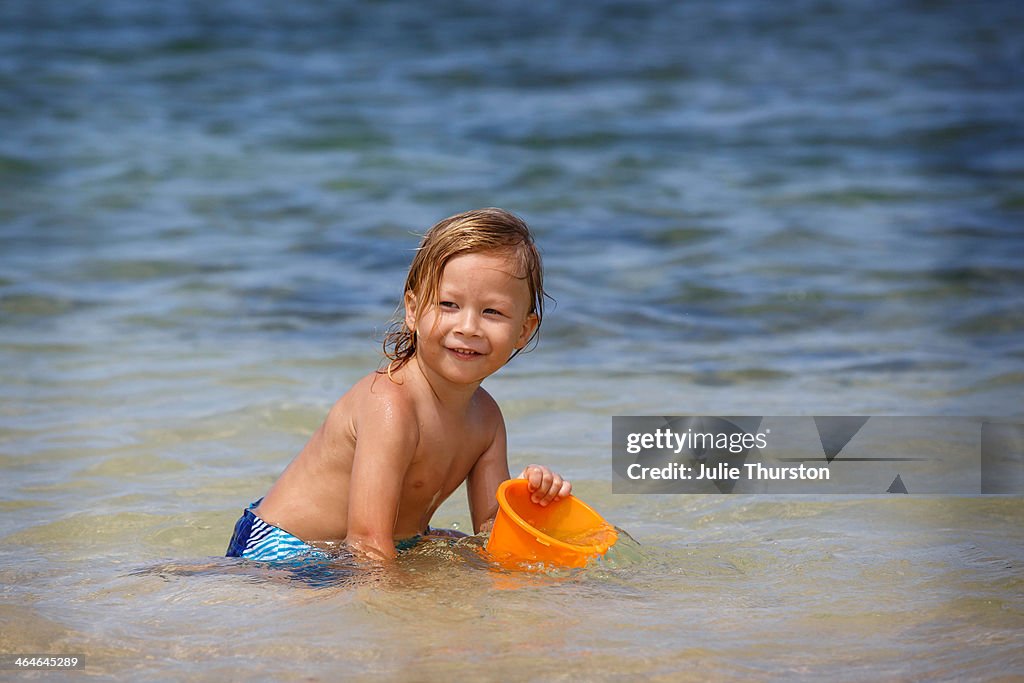 Boy Playing With Bucket at the Beach in Hawaii