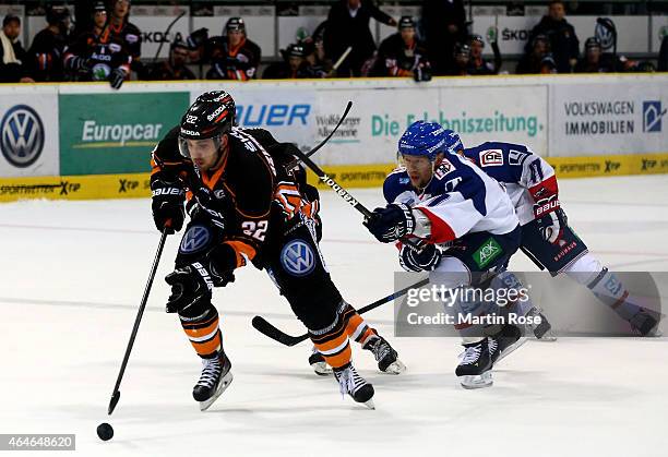 Matt Dzieduszycki of Wolfsburg and Brandon Yip of Mannheim battle for the puck during the DEL match between Grizzly Adams Wolfsburg and Adler...