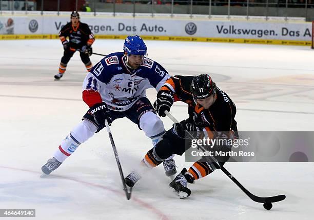 Sebastian Furchner of Wolfsburg and Andrew Joudrey of Mannheim battle for the puck during the DEL match between Grizzly Adams Wolfsburg and Adler...