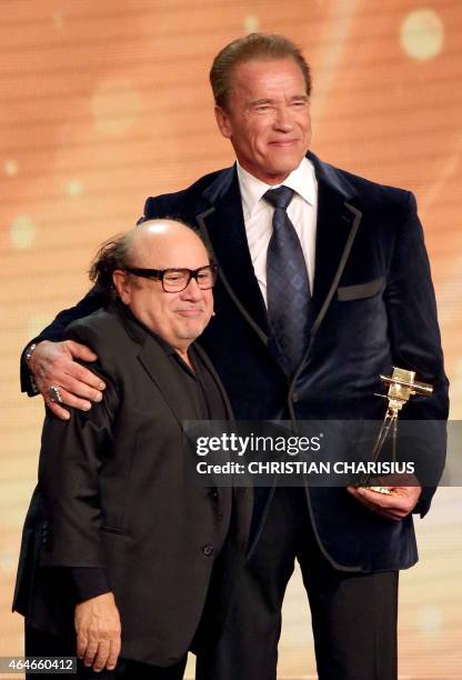 Actor Danny DeVito and US actor and former governor of California Arnold Schwarzenegger stand on stage after Schwarzenegger was awarded the lifetime...