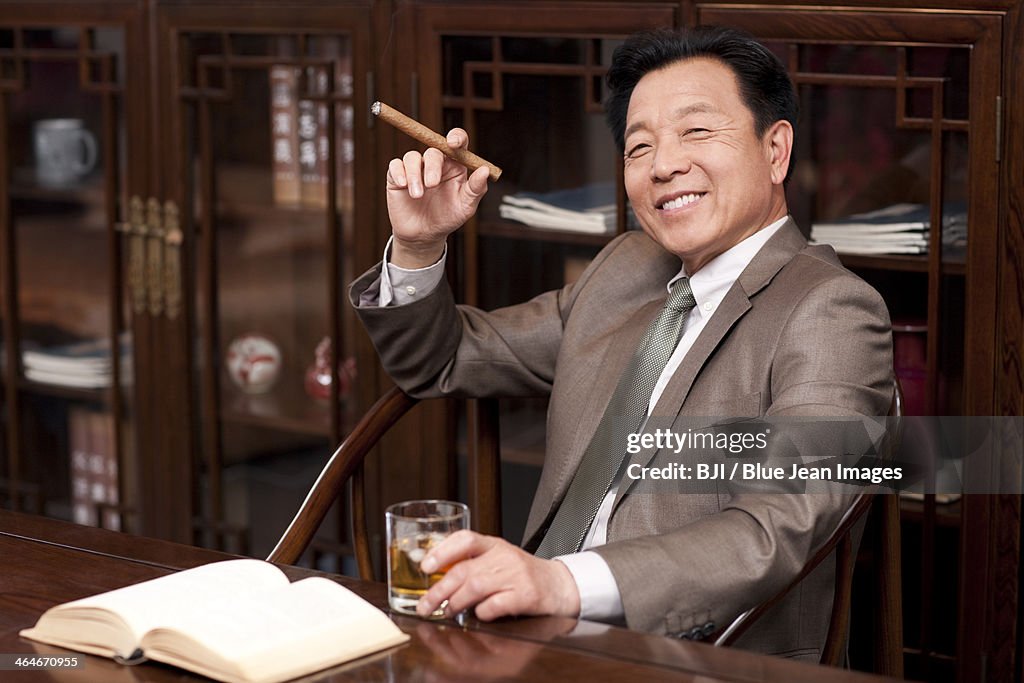 Successful businessman enjoying cigar