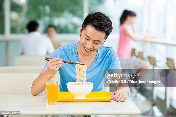 young man having a meal in restaurant - noodles eating stock pictures, royalty-free photos & images