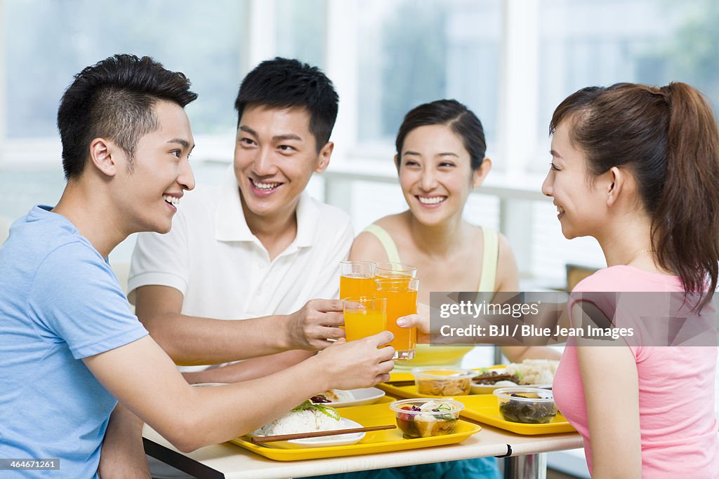 Young adults celebrating with orange juice