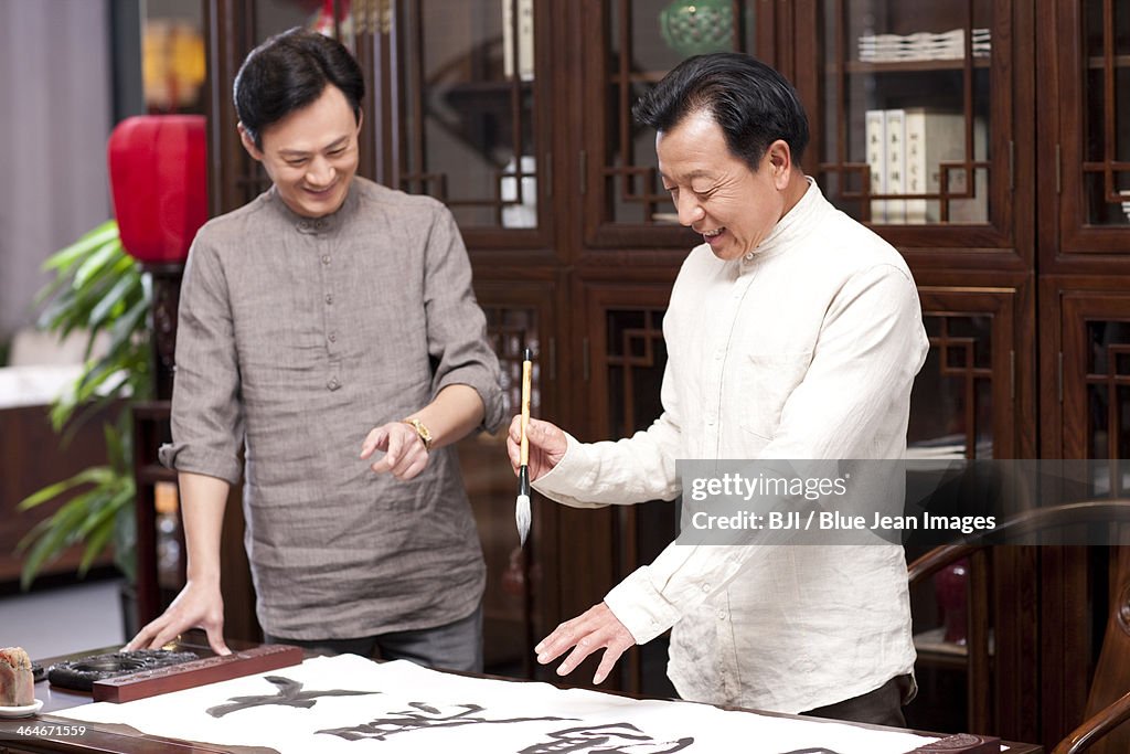 Male friends practicing calligraphy in the study