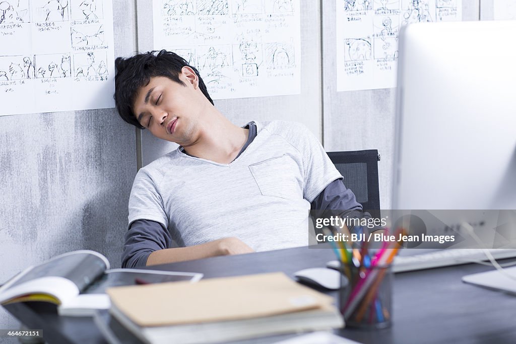 Young man taking a nap in the office