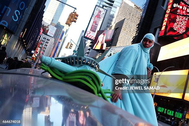 Man dresses up as the "Statue of Liberty" at Times Square in New York on February 27, 2015. Dozens of men and women earn their livelihood dressing up...