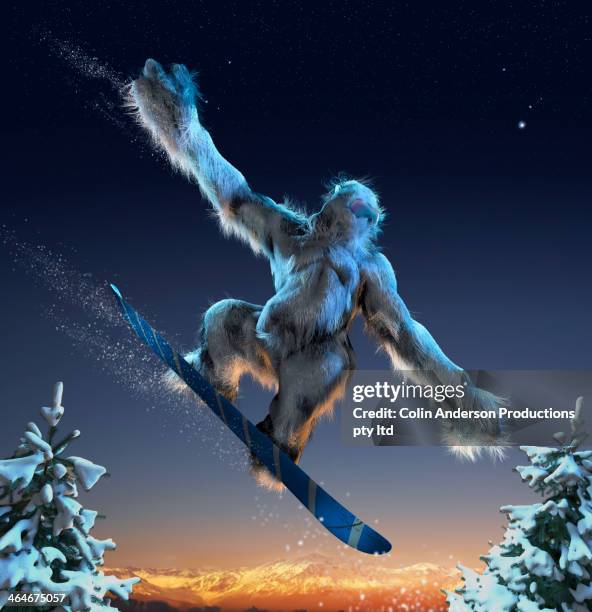 yeti riding snowboard mid-air - yeti stockfoto's en -beelden
