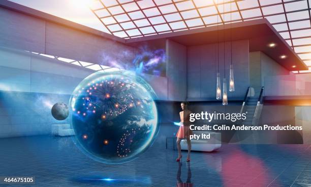 caucasian businesswoman examining virtual globe - planetary gear stockfoto's en -beelden