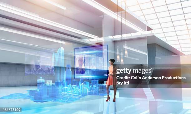 caucasian businesswoman using hologram computer screen - futuristic office stock-fotos und bilder