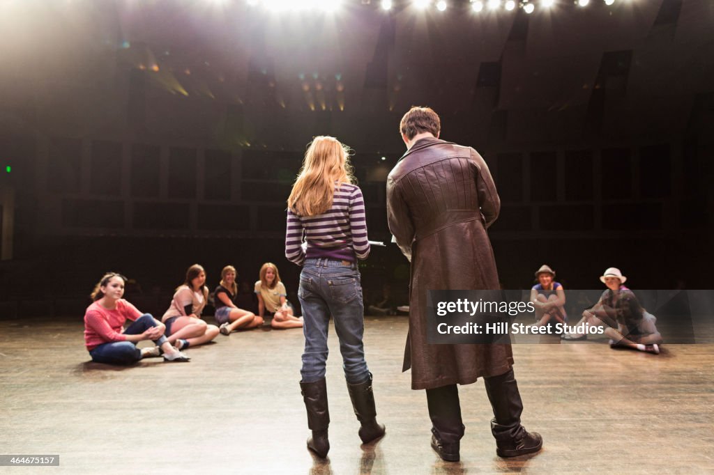 Students practicing lines on stage