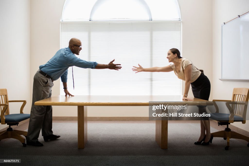 Business people shaking hands across table