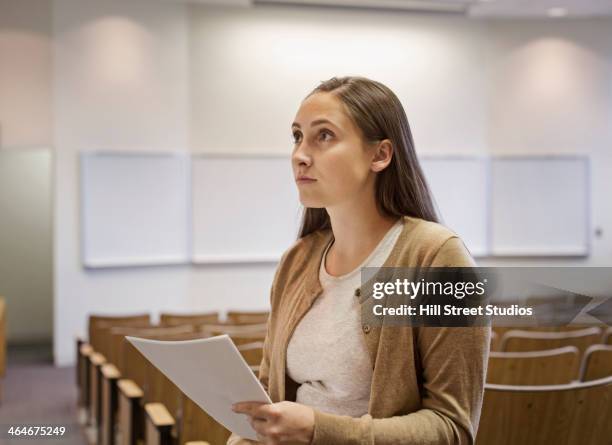 female student holding essay in lecture hall - tensed idaho stock pictures, royalty-free photos & images