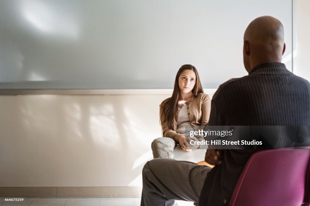 Student and psychologist talking in classroom