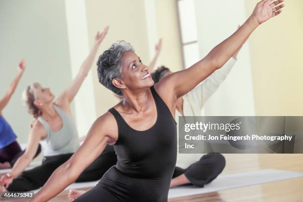 older women stretching in yoga class - human body foto e immagini stock