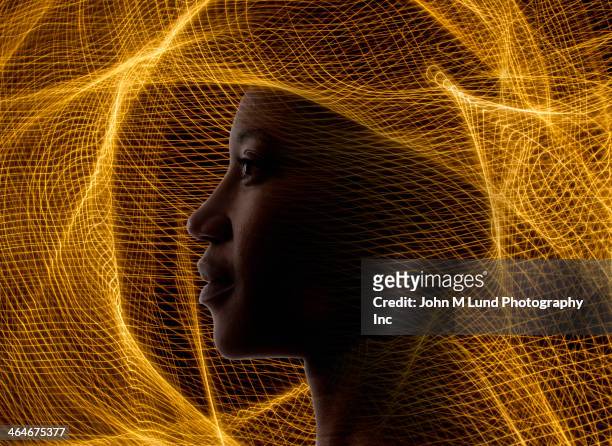 african american woman surrounded by golden netting - circondare foto e immagini stock