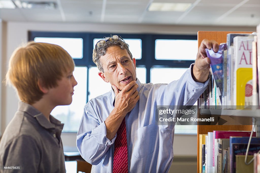 Teacher and student working in library