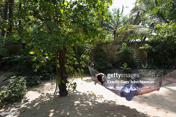 woman reading in hammock at homestay in india - kochi india photos et images de collection