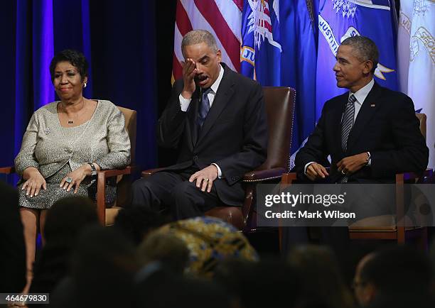 Attorney General Eric Holder wipes away tears while seated next to US President Barack Obama and singer Aretha Franklin who just finished singing...