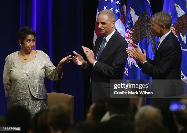 Attorney General Eric Holder and US President Barack Obama applaud after singer Aretha Franklin finished singing America The Beautiful during a...