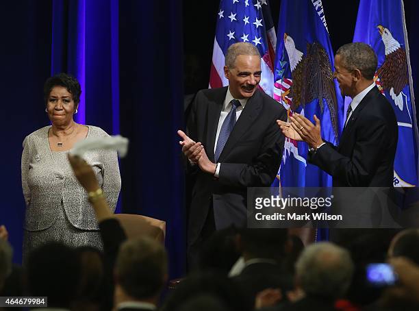 Attorney General Eric Holder and US President Barack Obama applaud after singer Aretha Franklin finished singing America The Beautiful during a...