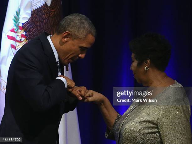 President Barack Obama fist bumps with singer Aretha Franklin who sung during a farwell ceremony for Attorney General Eric Holder at the Justice...