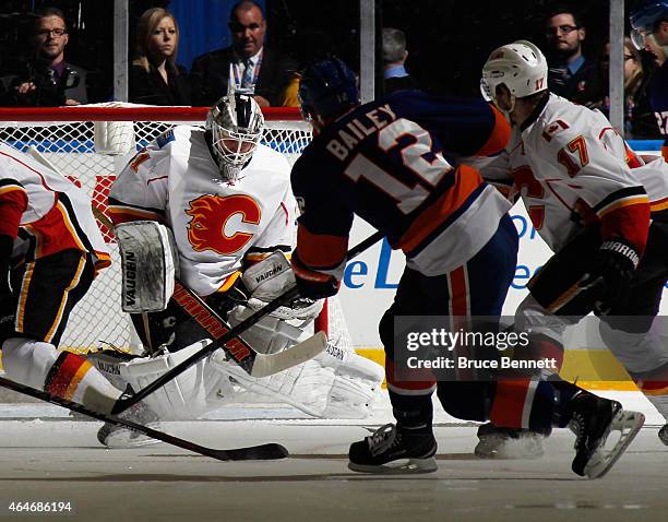 Karri Ramo of the Calgary Flames makes the first period save on Josh Bailey of the New York Islanders at the Nassau Veterans Memorial Coliseum on...