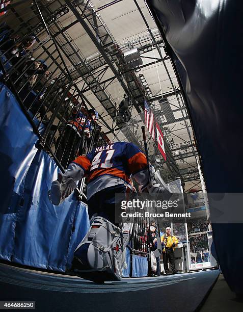 Jaroslav Halak of the New York Islanders leads the team out for the game against the Calgary Flames at the Nassau Veterans Memorial Coliseum on...