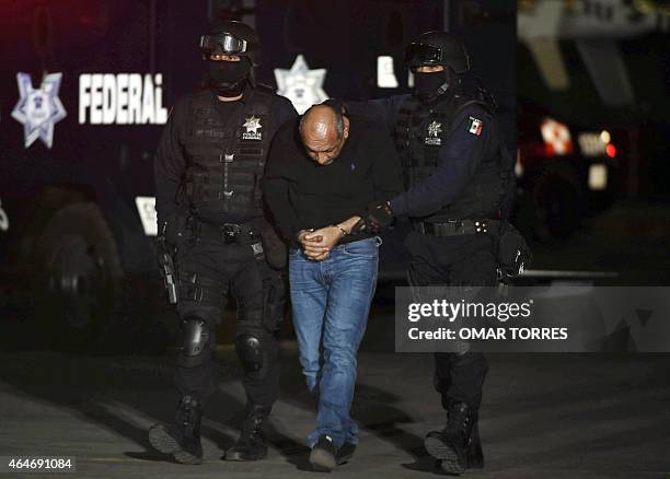 Mexican federal police escort Servando Gomez , aka "La Tuta" from a helicopter upon his arrival at the airport in Mexico City on February 27, 2015....