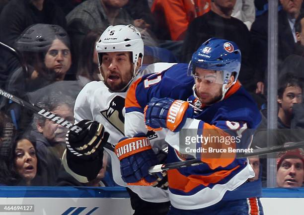 Frans Nielsen of the New York Islanders checks Deryk Engelland of the Pittsburgh Penguins into the boards during the first period at Nassau Veterans...