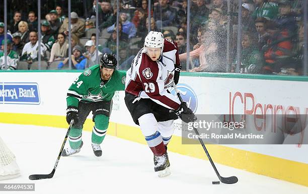 Nathan MacKinnon of the Colorado Avalanche skates the puck against Jordie Benn of the Dallas Stars in the second period at American Airlines Center...