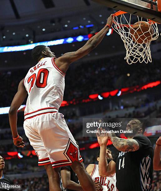 Tony Snell of the Chicago Bulls dunks over Nikola Pekovic of the Minnesota Timberwolves at the United Center on February 27, 2015 in Chicago,...