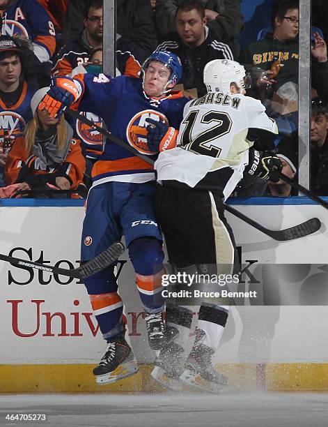 Chuck Kobasew of the Pittsburgh Penguins checks Calvin de Haan of the New York Islanders during the second period at Nassau Veterans Memorial...