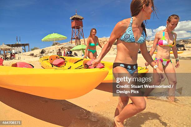 young women pull a boat into the water from the beach at cabo pulmo - young teen bathing suit stock pictures, royalty-free photos & images