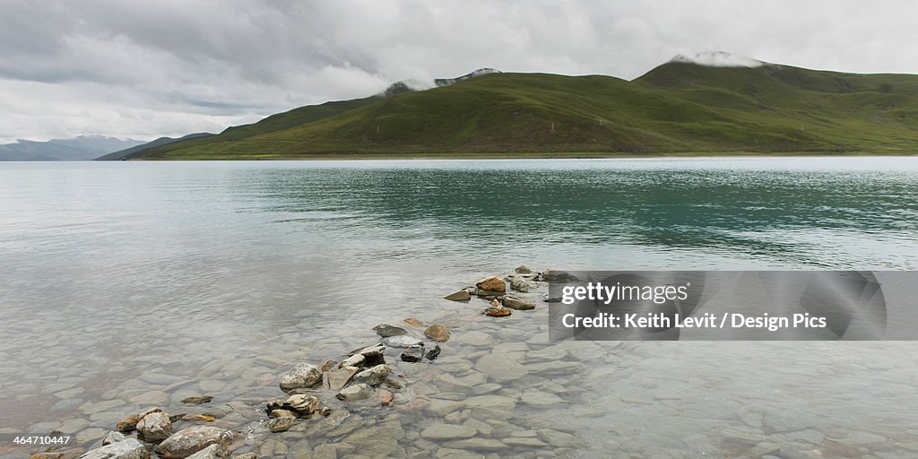 Shoreline of sacred lake under a cloudy sky