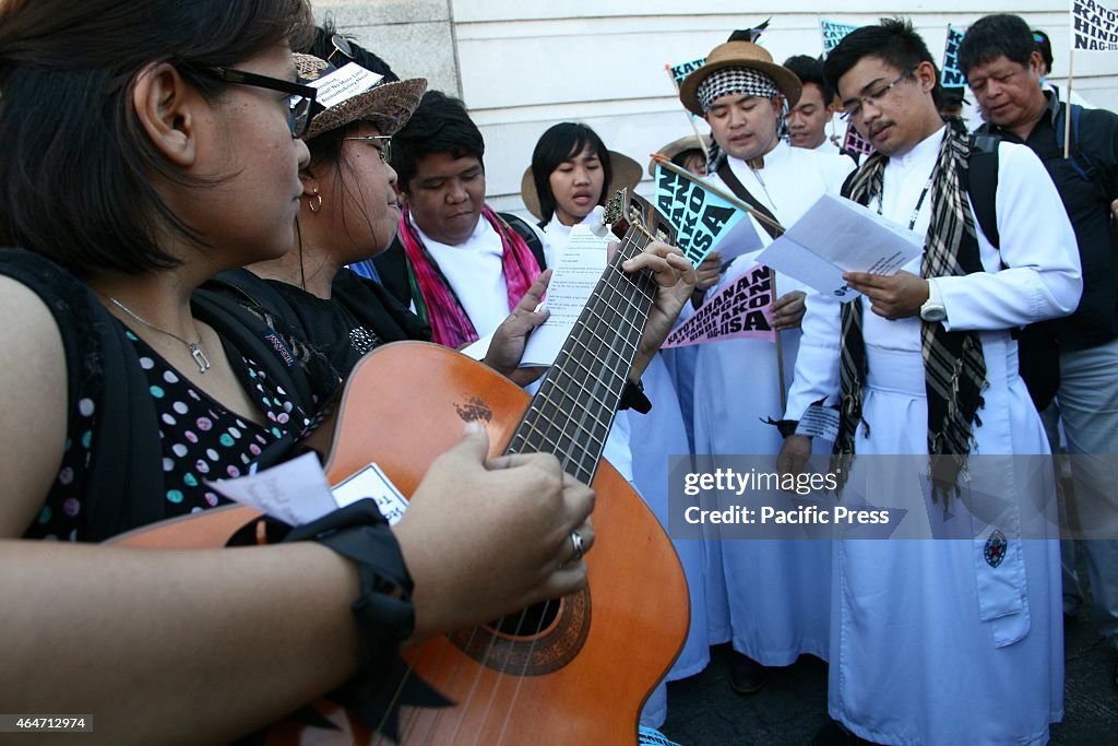 Protesters and seminarians hold a short program in front of...