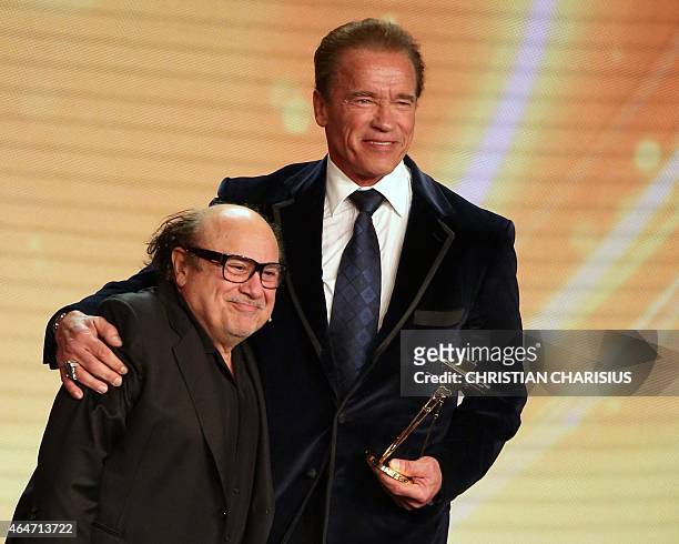 Actor and former governor of California Arnold Schwarzenegger poses after receiving from US actor Danny DeVito his lifetime achievement award at the...