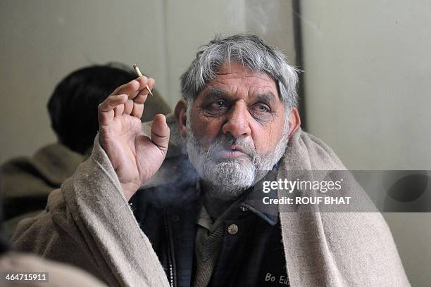 Pakistan-India-Kashmir-crime-trade,FOCUS by Parvaiz Bukhari A stranded truck driver from Pakistan-administered Kashmir smokes a cigarette while...