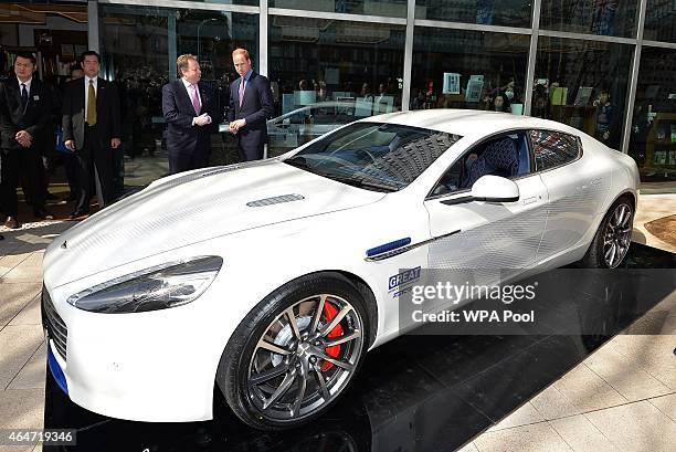 Prince William, Duke of Cambridge and Mark Palmer, CEO of Aston Martin, pose with an Aston Martin Rapide S during a visit to the British designed...