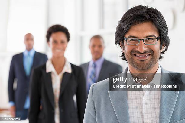 a business environment, a light airy city office. business people. a team of people, a department or company. three men and one woman. - indian woman short hair stock pictures, royalty-free photos & images