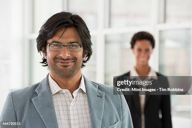 a business environment, a light airy city office. business people. a man and a woman. - indian woman short hair stock pictures, royalty-free photos & images