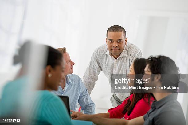 an office in the city. business. a multi ethnic group of people around a table, men and women. teamwork. meeting. - indian woman short hair stock pictures, royalty-free photos & images