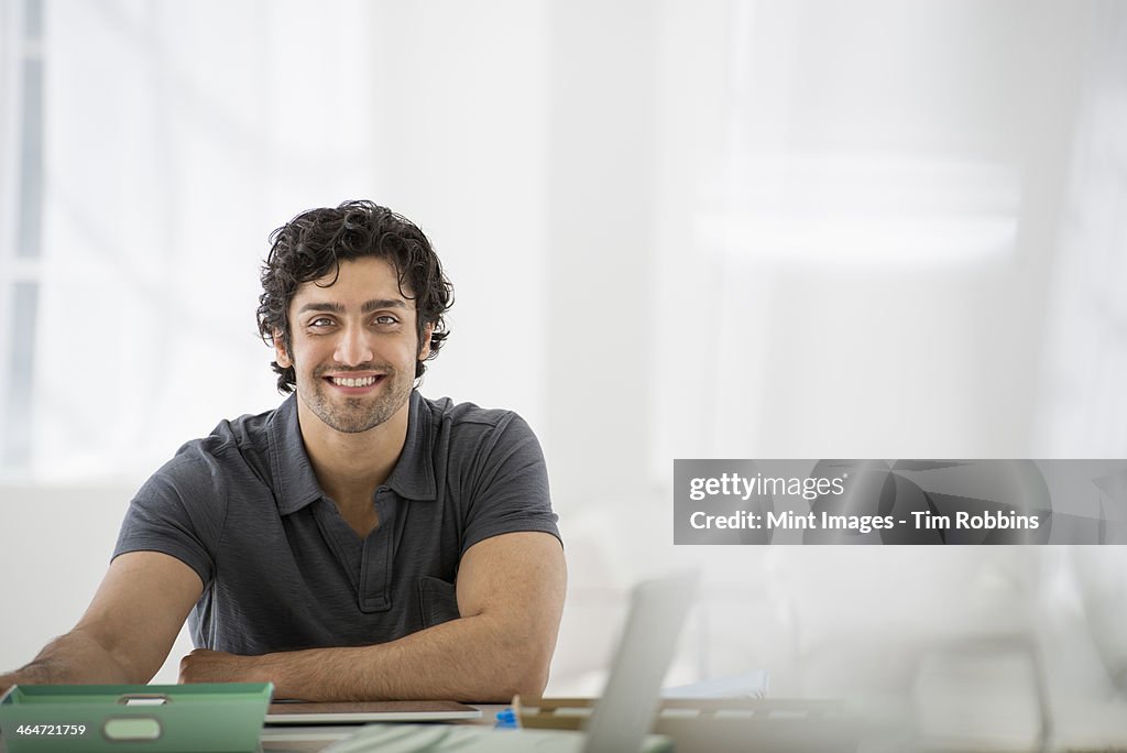 An office in the city. Business. A man sitting in a relaxed pose behind a desk.
