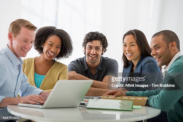 an office in the city. business. team meetings. a group sitting down around a table. one person in the foreground. - indian woman short hair stock pictures, royalty-free photos & images